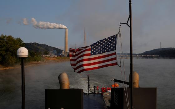 A towboat passes a coal-fired power plant along the Ohio River Sept. 10, 2017, in Stratton, Ohio. (CNS/Reuters/Brian Snyder)