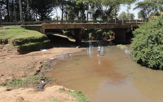 A man walks in the Murungato River in search of sand. The Kalondon River splits from the Murungato River toward Mathari. (Courtesy of Shadrack Omuka)