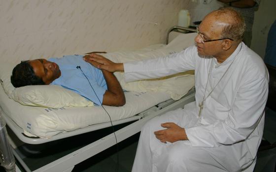 Cardinal Oswald Gracias of Mumbai, India, consoles Fr. Bernard Digal at Mumbai's Holy Family Hospital Sept. 6, 2008. Digal was severely beaten by Hindu extremists and left to die in the Kandhamal jungles Aug. 26, 2008, during anti-Christian violence. (CNS/Anto Akkara) 