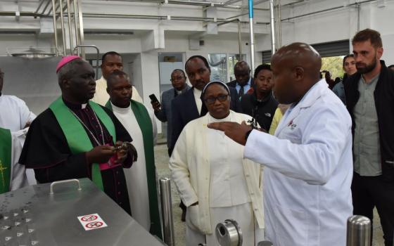 Archbishop Philip Arnold Subira Anyolo of Nairobi, Kenya, is pictured listening to Michael Kiburi, acting CEO of Caritas Dairy and the deputy director of programs, Caritas Nairobi, during the opening of a milk processing plant in Nairobi on Nov. 16, 2023. (OSV News photo/courtesy Caritas Nairobi)