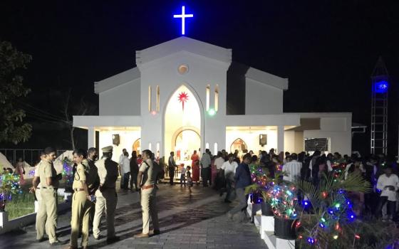 	Police officers stand outside St. Thomas Church, Chittoor, on the outskirts of Kochi, Kerala, during the Christmas midnight Mass as protesters demanded the synodal Mass. (Thomas Scaria)