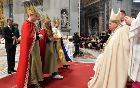 Pope Francis greets children dressed as the Magi as he accepts the offertory gifts during Mass for the feast of Mary, Mother of God, and World Peace Day on New Year's Day in St. Peter’s Basilica at the Vatican Jan. 1. (CNS/Vatican Media)