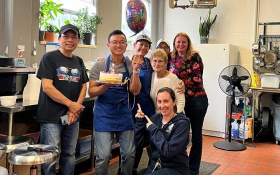  Tuan Anh Nguyen holds a cake as he celebrates his first anniversary at an apostolate in Seattle. He is one of three men exploring calls to the priesthood who live at a Jesuit discernment house. (RNS/Courtesy photo)