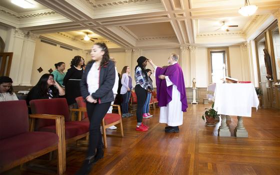 Paulist Fr. Rich Colgan distributes ashes during Ash Wednesday Mass at Trinity Washington University Feb. 26, 2020. Paulists serve in nine U.S. states and the District of Columbia, primarily at parishes, college centers, and through various ministries, programs and offices. (CNS/Tyler Orsburn)