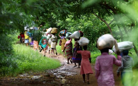 Flood victims from Mtauchira village carry food they received from the Malawi government in Blantyre March 16, 2023, in the aftermath of Cyclone Freddy that destroyed their homes. (OSV News photo/Esa Alexander, Reuters)