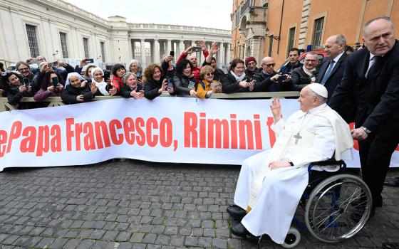 As Pope Francis exits the Paul VI Audience Hall after his weekly general audience at the Vatican Feb. 28, 2024, a group of people greet him. (CNS/Vatican Media)