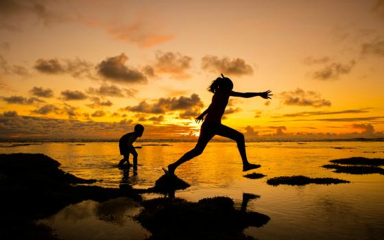 Two people, one chasing the other, amid sunset 