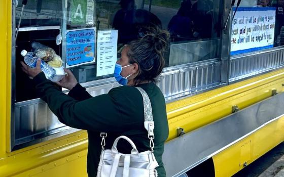 A guest receives lunch from the Feed My Poor food truck in MacArthur Park, just west of downtown Los Angeles.