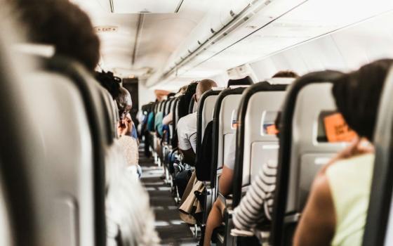 Inside airplane, people sit in seats.