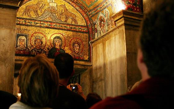 A group of women on a pilgrimage sponsored by FutureChurch views a ninth-century mosaic in Rome's St. Praxedis Church, in this 2006 file photo. The mosaic shows the Blessed Virgin Mary, Sts. Praxedis and Pudentia, and a woman, Theodora, who has the word "Episcopa" inscribed above her. FutureChurch advocates the ordination of women priests and dispensing with the celibacy requirement for priests. (CNS/Carrie Leonard)