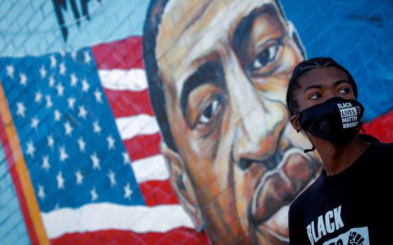 A person in the Brooklyn borough of New York City attends a birthday vigil for George Floyd Oct. 14, 2020; Floyd was pinned down May 25, 2020, and died at the hands of a white police officer. Black Catholic leaders, intellectuals, writers and activists told NCR that current realities pertaining to racism demand a deeper commitment from the U.S. bishops. (CNS/Reuters/Brendan McDermid)