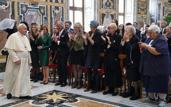 Pope Francis walks along line of assembled foundation members