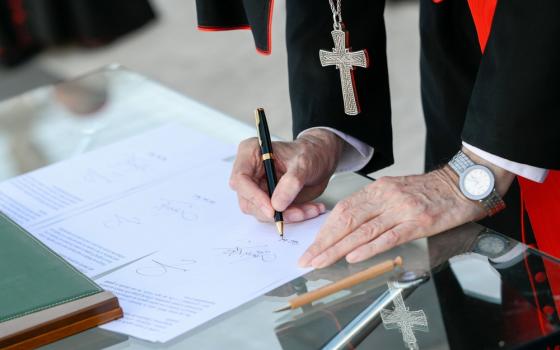 Cardinals hands and pectoral cross visible