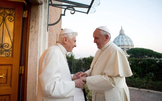 Pope Francis and Pope Emeritus Benedict XVI greet warmly.