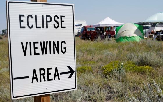 Metal sign points toward tents