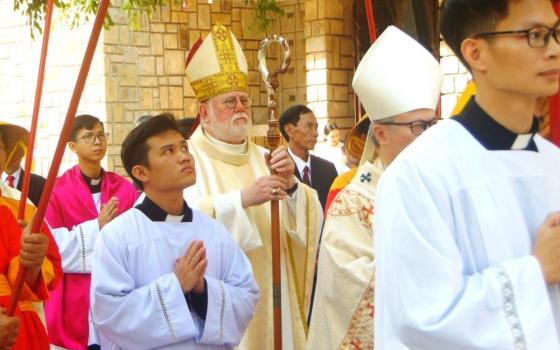 Archbishop Paul Gallagher, the Vatican's foreign minister, walks in a procession to enter Phu Cam Cathedral in Hue for a Mass on April 12. 