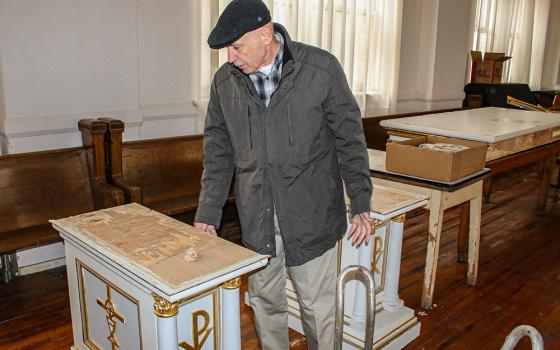 Parishioner Bob Purgert looks at one of the damaged pedestals of the dismantled altar at St. Elizabeth of Hungary Church in Cleveland. (Dennis Sadowski)