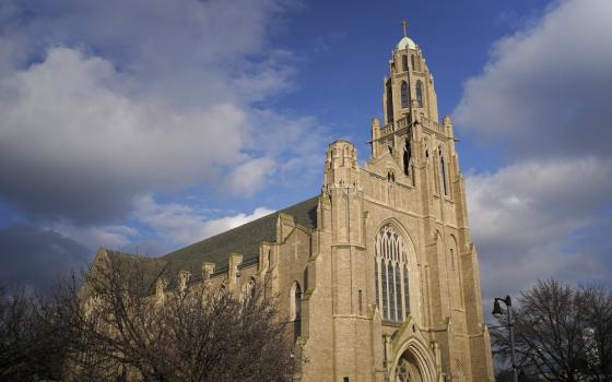 Cathedral's spire against clouded sky. 