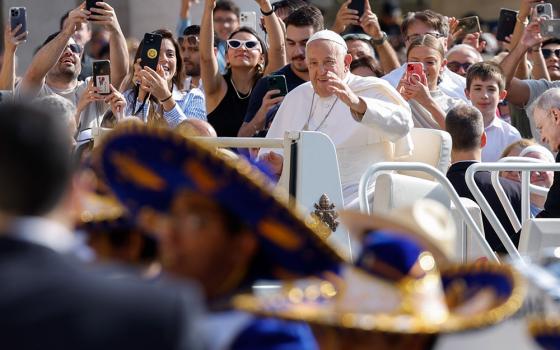 Pope Francis greets visitors as he rides the popemobile around St. Peter's Square before his weekly general audience at the Vatican May 29, 2024. (CNS/Lola Gomez)