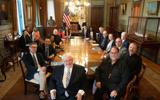 Groups sits in circle around large conference table