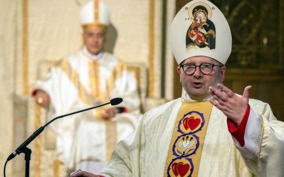 Bishop Waller, vested, speaks at lectern, while Cardinal Fernandez, also vested, sits ex cathedra. 