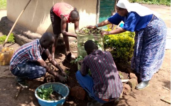 Sr. Zipporah Ngoiri Waitathu, right, demonstrates how to make a garden in a sack.