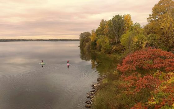 A lake with two paddleboarders (Unsplash/Alex Guillaume)