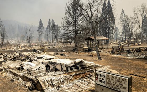 Marquee stands next to burnt ruins and scorched ground.