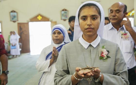 Vincentian Sr. Teagon Andre Maria receives a cross from Bishop Paul Ponen Kubi at St. Patrick's Cathedral Church on June 24 in Mymensingh, Bangladesh, during her vows as a Sister of Charity of St. Vincent de Paul. (GSR photo/Stephan Uttom Rozario)