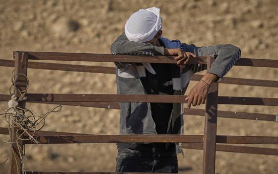 A Bedouin sheep farmer weeps in Uum Jamal, a small West Bank village, as he packs up his family's belongings Aug. 16. Israeli settlers harassed and threatened the community for a week, finally convincing them to leave. A Christian delegation from the U.S., which included Catholics, provided a protective presence as the farmers evacuated. (Life on Earth Pictures/Paul Jeffrey)