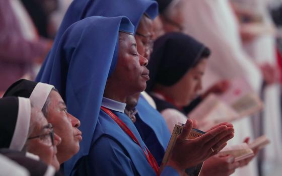 Religious sisters pray during Holy Qurbana July 20 at Lucas Oil Stadium in Indianapolis during the National Eucharistic Congress. Holy Qurbana is the name for Mass in the Catholic Church's Syro-Malabar rite. (OSV News/Bob Roller)