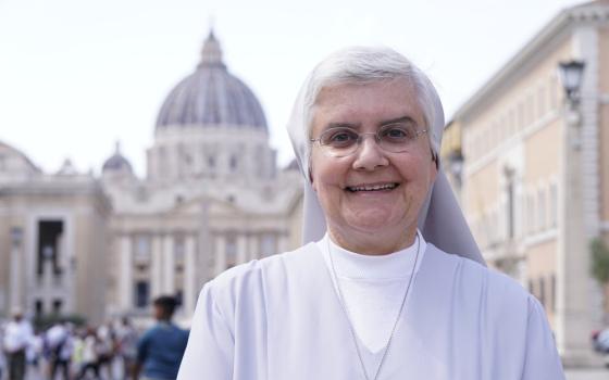 Sister Carneiro stands smiling, behind her, out of focus, is St. Peter's facade and dome.