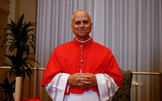 Prevost in red choir dress poses with folded hands.