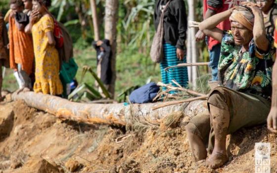 A person reacts as an area is cleared at the site of a landslide in Yambali village, Enga Province, Papua New Guinea, May 27. Pope Francis visited the Pacific country — among the top-20 countries most vulnerable to climate change — during his Sept. 2-13 trip to Asia and Oceania. (OSV News/UNDP Papua New Guinea handout via Reuters)