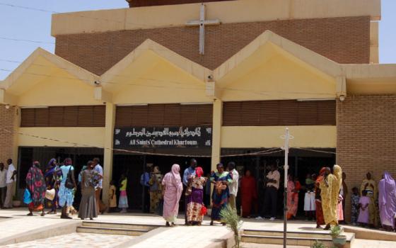 Exterior of cathedral with people out front. 