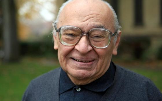 An elderly Gutiérrez faces camera with warm, beaming smile. 