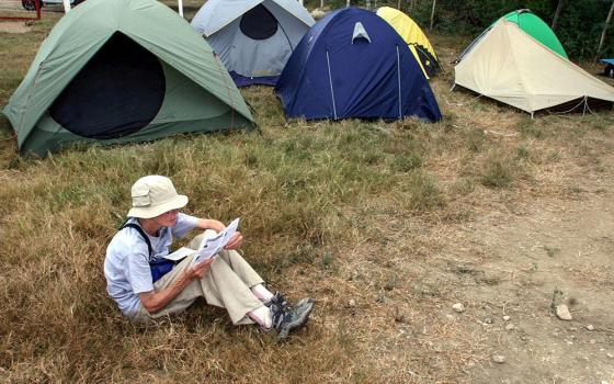 Sr. Anne Montgomery, a member of the Christian Peacemakers Team, reads outside the "Witness Against Torture" camp at the military zone boundary near the U.S. detention facility in Guantanamo Bay, Cuba, Dec. 13, 2005. (CNS/Reuters) 