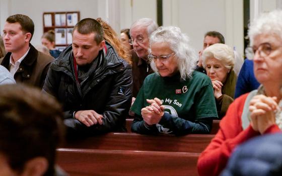 Debra Tice and her son Simon Robert pray during a Vigil Mass Dec. 15 at Holy Trinity Church in Washington. (NCR photo/Anthony Peltier)