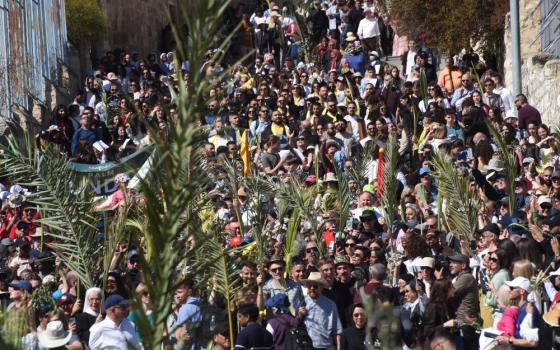 Christians carry palm fronds as they walk the traditional path that Jesus took on his last entry into Jerusalem during the Palm Sunday procession on the Mount of Olives in Jerusalem April 2, 2023. 