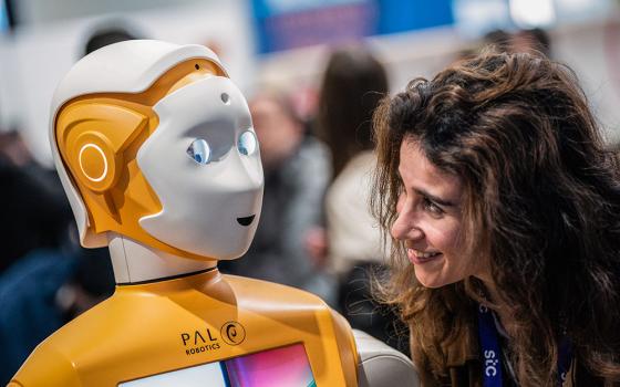 A visitor speaks with a PAL Robotic robot during the Mobile World Congress 2023 in Barcelona, Spain, on March 1, 2023. (AP/Joan Mateu Parra)