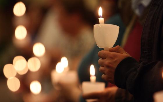 Pictured are worshippers holding candles in this 2012 photo. Church leaders have a crucial role and duty in rebuilding trust after the sexual abuse scandals involving clerics and other church representatives, writes Sr. Matilda Owolagba. (CNS file/Gregory A. Shemitz)