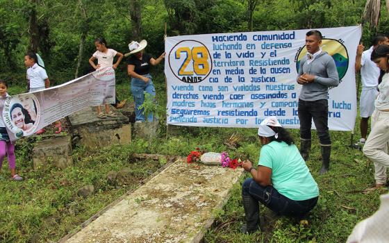Community leader Germán Gracianos, right, speaks at the gravesite of Édinson David in La Esperanza, Colombia, on March 23, 2025. The Peace Community of San José de Apartadó, Colombia, began its 28th anniversary celebration with a pilgrimage to the gravesites of two members killed in 2024. (Tracy L. Barnett)