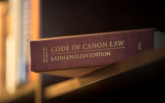 A Latin-English edition of the Catholic Church's Code of Canon Law is pictured on a bookshelf. 