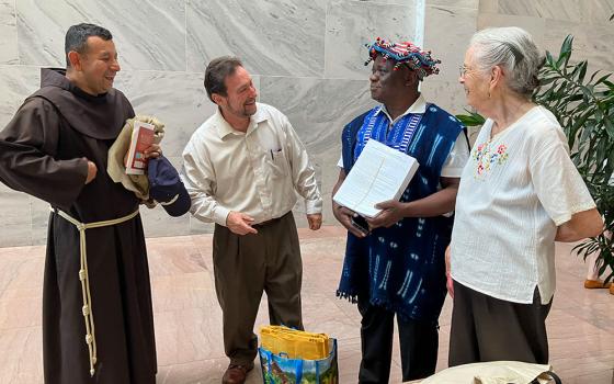 Franciscan Fr. Juan de la Cruz Turcios, Russ Testa, Dominique Njinkeu and Mary Rein prepare to deliver letters (held by Njinkeu) to members of Congress June 26, 2025, seeking protection for immigrants, on behalf of St. Camillus Parish in Silver Spring, Maryland. (NCR photo/Patricia Zapor)