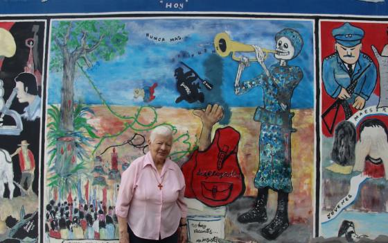 Sr. Maritze Torres explains the "triptica," a mural taking viewers through Trujillo's bloody past (on the right), to its present marked with struggles for justice (center), to its hopeful future, filled with abundance, education, good health and good fortune. (Tracy L. Barnett)