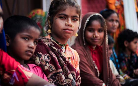 A row of girls sit together.