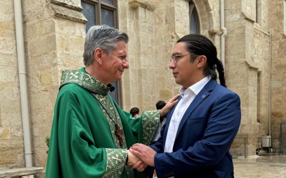Antonio Frietze, who helped lead an effort for the Archdiocese of San Antonio to join the Laudato Si Platform, shakes hands with Archbishop Gustavo Garcia-Siller during a mass celebrating making a climate action commitment. (Courtesy of Catholic Climate Covenant)
