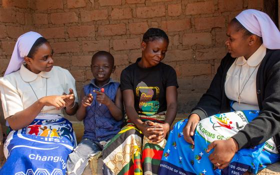 Sr. Ruth Kuyumba, right, engages Memory Musonda and her son Joshua in a conversation during a home visit. Sr. Agnes Kateule, left, uses sign language to communicate with Joshua. Memory and Joshua were beneficiaries of the recently defunded Inclusive Family Strengthening project, formerly managed by the Sisters of Mercy with support from Catholic Relief Services. (Derrick Silimina)