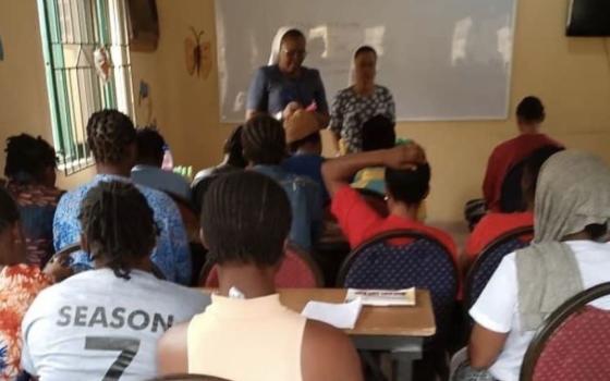 Religious Sisters of Charity Sr. Edidiong Etim, prison chaplain, talks with inmates at the Kirikiri Correctional Facilities in Lagos, Nigeria. The Religious Sisters of Charity teach inmates how to produce creams, candles, perfume and liquid soap as part of their ministry to help them reintegrate into society upon release. (Courtesy of Edidiong Etim)