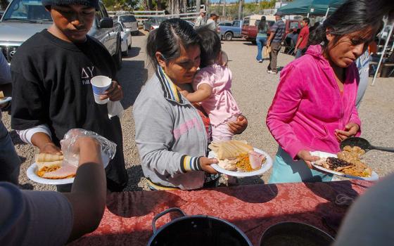 A file photo shows migrant workers receiving lunch in San Diego, helped by parishioners from a local Catholic church that assists laborers in the area. (OSV News/David Maung)